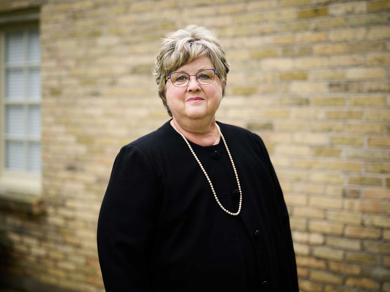 Dr. Susan McNair's portrait taken in front of a brick wall